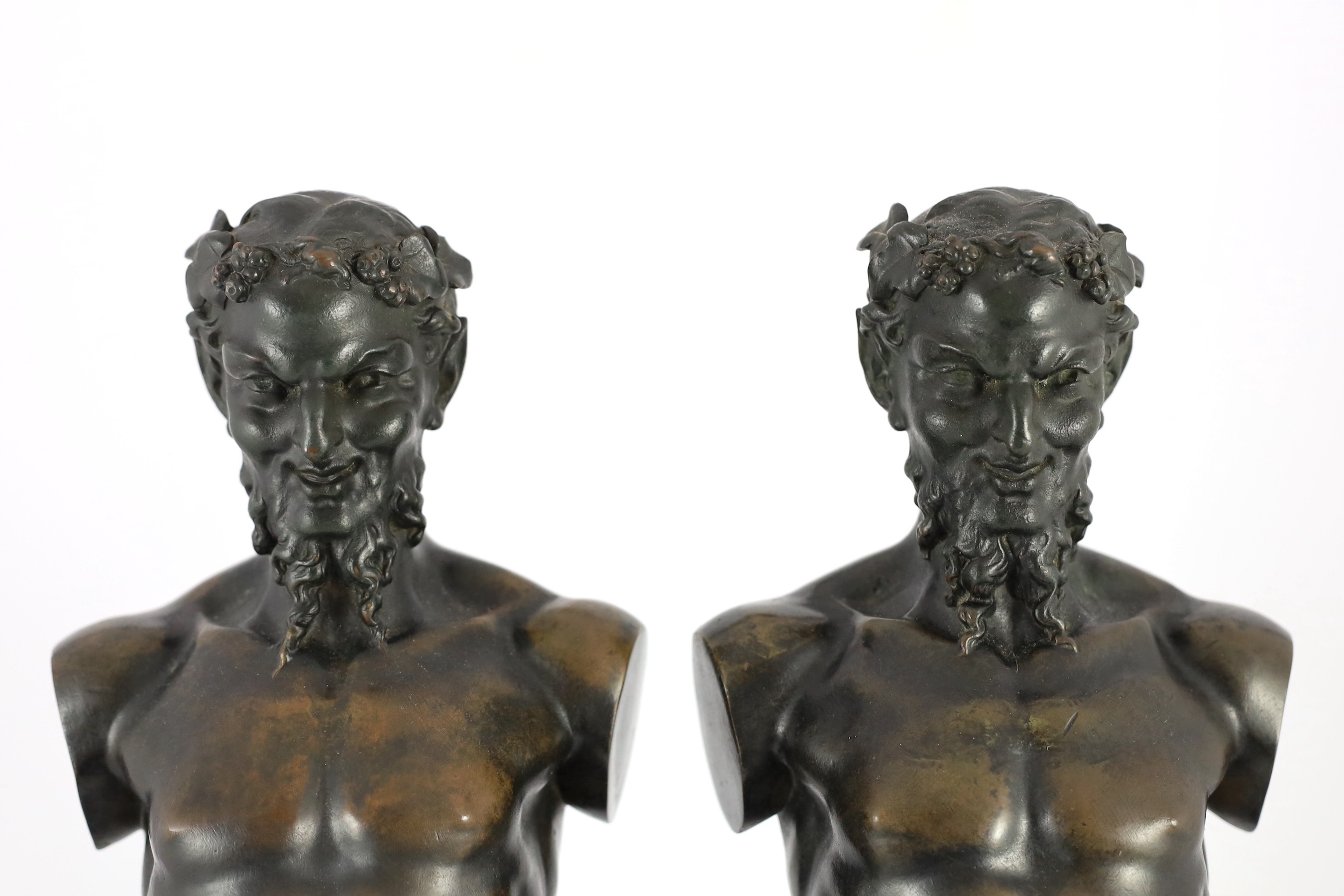 A pair of early 20th century French bronze terms, each in the form of a satyr, 16cm wide 62cm high